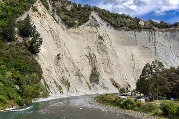 Campground at Rangitīkei River canyon, Managweka, New Zealand. Summer camping. Tents and campervans below clay papa cliffs. Manawatū-Whanganui region. 