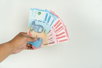 Hands Holding Indonesian Rupiah Banknotes 100000 and 50000 on White Background, Cash Money Concept, Finance and Economy