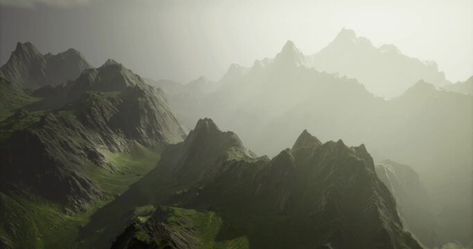 Majestic mountain ranges rise dramatically from lush green valleys, illuminated by the gentle glow of dawn. Clouds linger, adding a mystical touch to the scenic view.