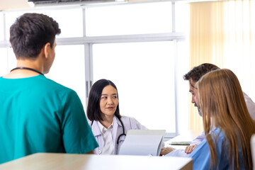 Fototapeta premium Team of diversity doctor and nurse is discussing and brainstorming over patient medical record after diagnosis for precise care plan with experienced senior physician specialist