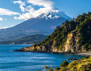 Volcanic mountain with snow-capped peak near a coast with lush trees