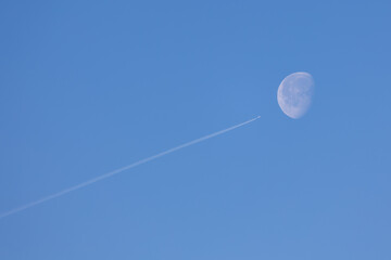 twin engined jet liner aircraft with contrails, in flight at high altitude, clear blue sky