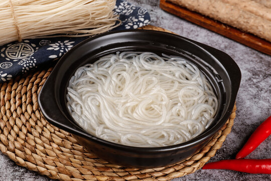 Traditional Asian Noodles in Black Bowl with Cooking Utensils