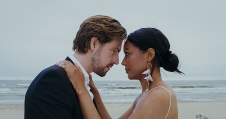 The bride and groom kiss standing on the seashore