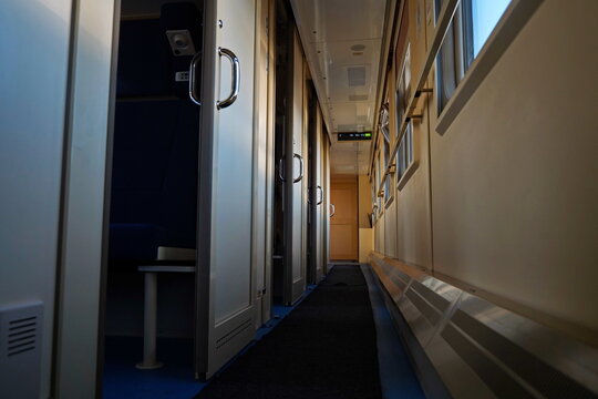 Passage in a passenger train carriage with a compartment.