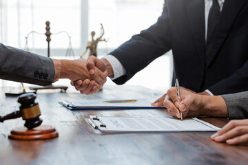 Legal professionals completing a deal, clients signing documents with a lawyer negotiating terms, symbolizing justice and agreement © amnaj