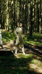 Fototapeta premium Two women walk past a standing model, in the forest, vertical video