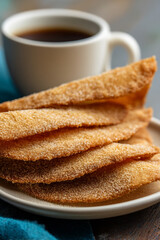 A close-up of Champurradas (giant cookies), crispy and thin, often dipped in coffee, with a light sugar dusting.