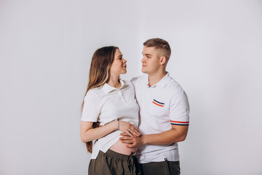 A married couple - a man and a pregnant woman together in the studio, beautiful and happy against an isolated background