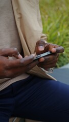 Man in headphones playing game on a mobile phone outdoors