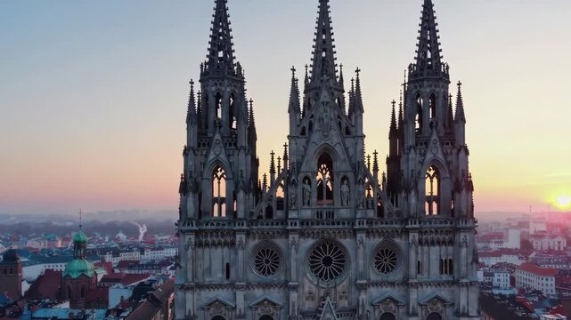 Aerial sunrise view of a cathedral roofline as the city awakens, highlighting timeless architecture.