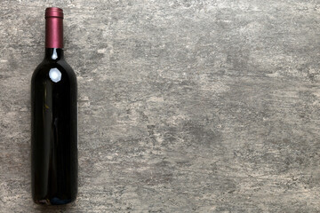 One Bottle of red wine on colored table. Flat lay, top view wth copy space