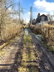 A dirt road with a house in the background