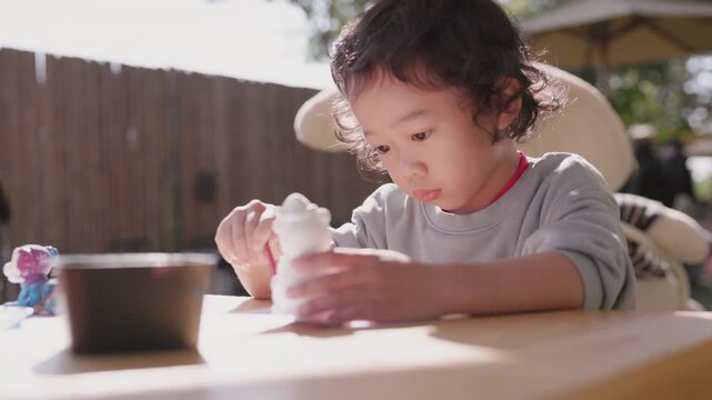 Child carefully coloring a plaster sculpture with a paintbrush, enjoying a creative DIY craft project that develops imagination, focus, artistic expression, fine motor skills, and creativity.