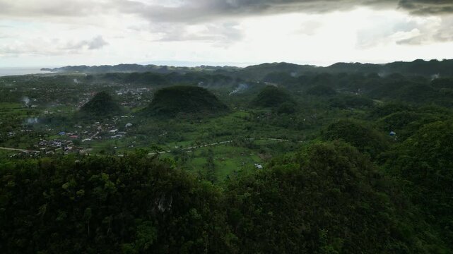 Breathtaking aerial drone shot of rolling hills at a tropical island province during a cloudy, overcast day - Catanduanes, Philippines