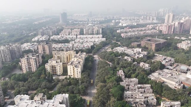 Aerial view of Greater Noida, showcasing planned residential blocks, wide tree-lined roads, and green buffers that highlight the city&rsquo;s structured urban development. Pollution in winter season.