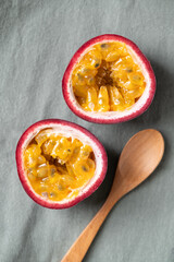 Fresh passion fruit and wooden spoon on fabric, Tropical fruit, Top view
