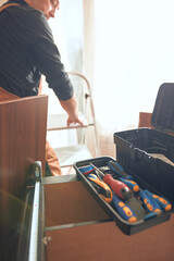 Carpenter working and assembling furniture in a new apartment.