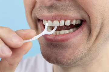 A man's Hand Cleaning Teeth With Dental Floss