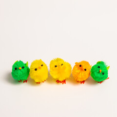 Naklejka premium Several small fluffy chick toys in a row on a white background, representing spring, new life, and Easter decoration.