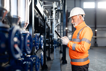 Senior engineer working with tablet in industrial plant