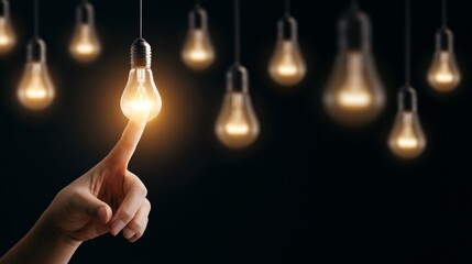 Illuminating ideas hand touches light bulb in dark environment conceptual art creative inspiration