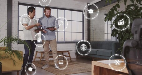 Reviewing tablets, colleagues in white blouse and blue shirt studying HUD icons in loft, copy space