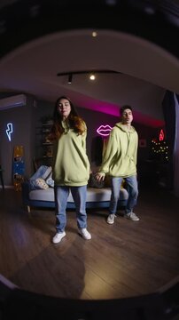 Gen z teenagers recording casual dance video in stylish purple room modern youth lifestyle and digital generation concept