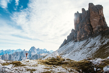 Trail runner conquers rugged mountain terrain under dramatic peaks