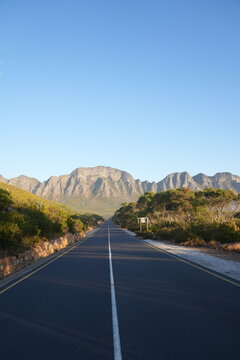 Open road on a scenic drive along the coast with a mountain range