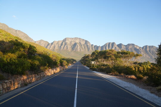 Open road on a scenic drive along the coast with a mountain range