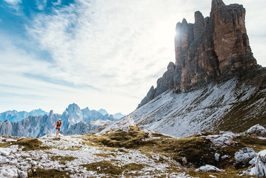 Trail runner conquers rugged mountain terrain under dramatic peaks