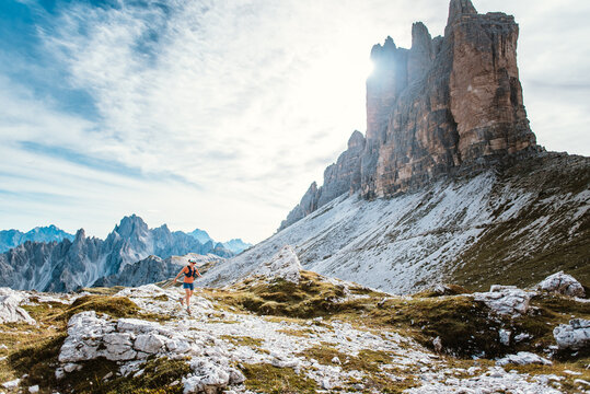 Trail runner conquers rugged mountain terrain under dramatic peaks