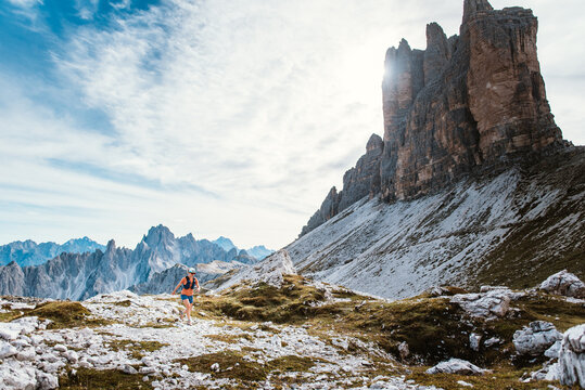 Trail runner conquers rugged mountain terrain under dramatic peaks