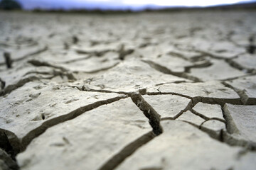 Cracked and dried mud in an empty dam, climate change image