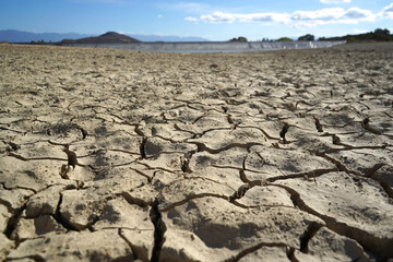 Cracked and dried mud in an empty dam, climate change image