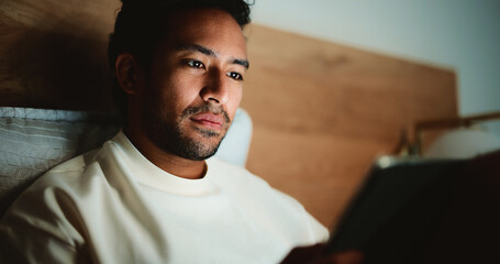 Tablet, relax and man in bed in house at night for watching movie, series or film for...