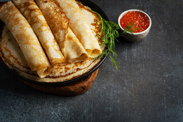 Stack of pancakes with caviar on plate
