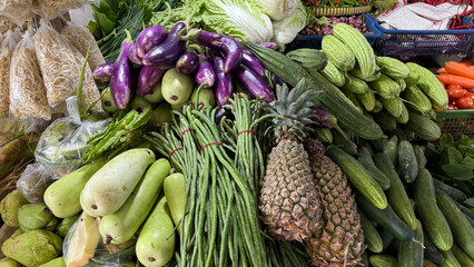A vibrant and abundant display of fresh, colorful vegetables and fruits at an outdoor market stall.
