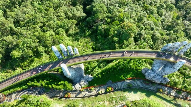 Aerial of the Hand Bridge in a French-style village surrounded by lush greenery on a high mountain in Da Nang, Vietnam.