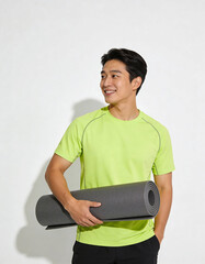 Young Asian man in sportswear holding a yoga mat and smiling