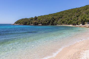 Fototapeta premium Secluded bay features crystal-clear turquoise water gently washing over a sandy shore