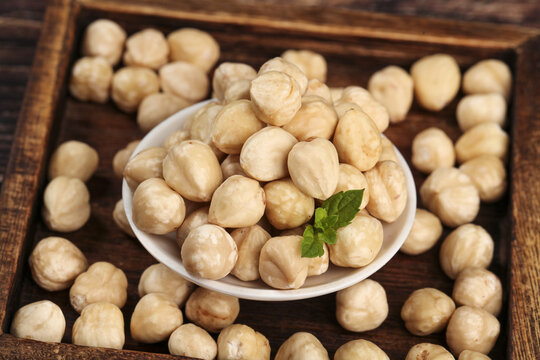 Roasted Hazelnuts in White Bowl on Wooden Tray with Mint