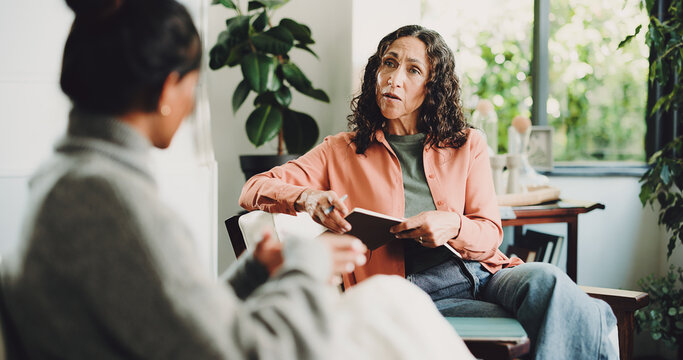Women, therapist and talking in office, evaluation or feedback for life coaching session. Discussion, psychologist or patient with anxiety, rehabilitation or person with depression or trauma recovery