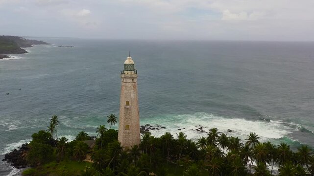 Seascape: Lighthouse and blue ocean with big waves and surf. Dondra, Matara, Sri Lanka.