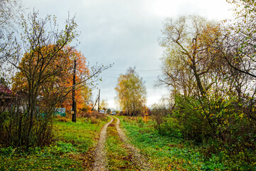 Dirt road through a village in late autumn