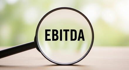 Magnifying glass over the word EBITDA, symbolizing financial analysis and business performance review