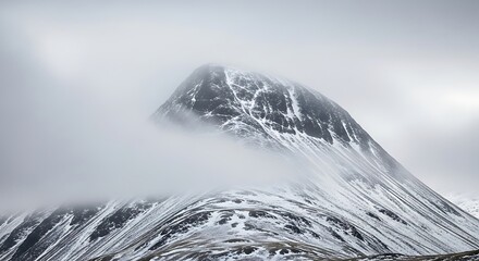 Snowy mountain peak in foggy weather.