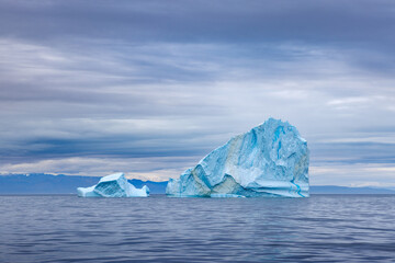 Blue icebergs in the cold, blue waters of the Arctic Ocean at Bontekoe Island, Northeast Greenland National Park.