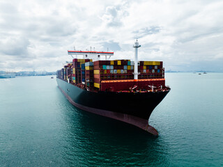 Close up aerial view of large cargo container ship sailing in sea for global business logistics and international import export trade transportation industry.